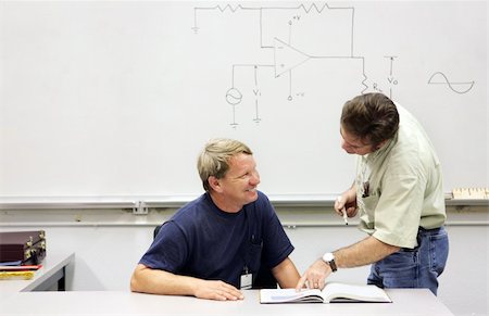 An adult technical college student smiling at his helpful teacher. Stock Photo - Budget Royalty-Free & Subscription, Code: 400-04486595
