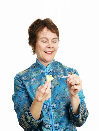 A woman reading the message from a fortune cookie.  Isolated on white. Stock Photo - Budget Royalty-Free & Subscription, Code: 400-04486635