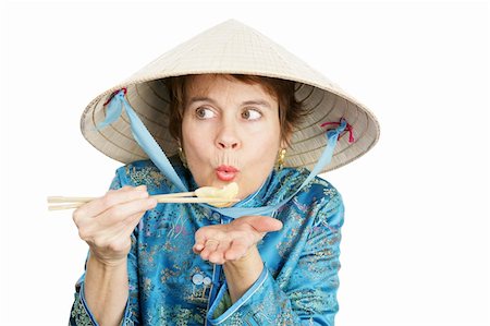 A tourist dressed in chinese clothing blowing on a fried dumpling to cool it.  Isolated on white. Stock Photo - Budget Royalty-Free & Subscription, Code: 400-04486849
