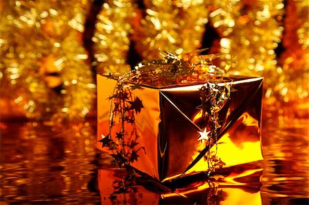 simsearch:400-06101480,k - Christmas gift in the box wrapped in gold paper on the shiny background of traditional decoration Stock Photo - Budget Royalty-Free & Subscription, Code: 400-04487594