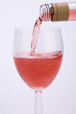 simsearch:400-04935153,k - A glass of rose wine being poured against a plain background. Photographie de stock - Aubaine LD & Abonnement, Code: 400-04487705