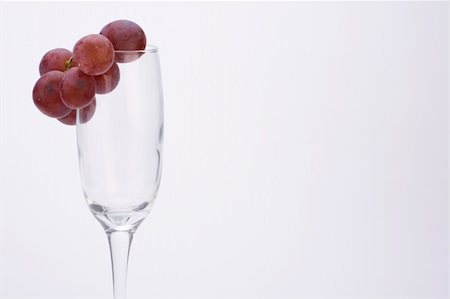 simsearch:400-04935153,k - A wine glass with grapes against a plain background. Photographie de stock - Aubaine LD & Abonnement, Code: 400-04487706