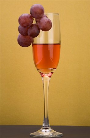 simsearch:400-04935153,k - A glass of rose wine with grapes against a plain background. Photographie de stock - Aubaine LD & Abonnement, Code: 400-04487702