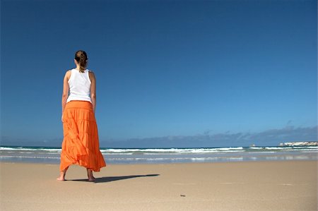 person spreading arms - Beautiful woman in the beach with a orange skirt Stock Photo - Budget Royalty-Free & Subscription, Code: 400-04488251