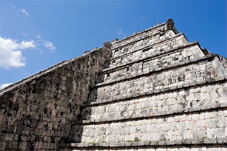 simsearch:400-05024773,k - Wall of Ancient Mayan Pyramid at Chichen Itza on the blue sky. Chichen Itza in the Yucatan was a Maya city and one of the greatest religious center and remains today one of the most visited archaeological sites Foto de stock - Royalty-Free Super Valor e Assinatura, Número: 400-04489482
