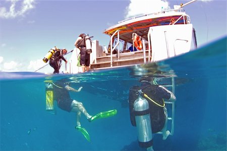 Scuba divers waiting around a dive boat in the tropics Stockbilder - Microstock & Abonnement, Bildnummer: 400-04489537