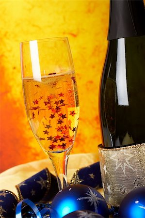 simsearch:400-05082002,k - Christmas decoration with champagne bottle and full glass with stars, over colour background. Shallow DOF Photographie de stock - Aubaine LD & Abonnement, Code: 400-04480463