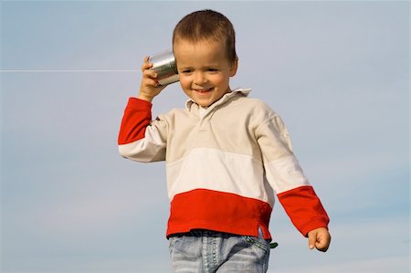 simsearch:400-05375851,k - Boy with tin can and string phone playing outdoors - blue sky background Foto de stock - Super Valor sin royalties y Suscripción, Código: 400-04482116