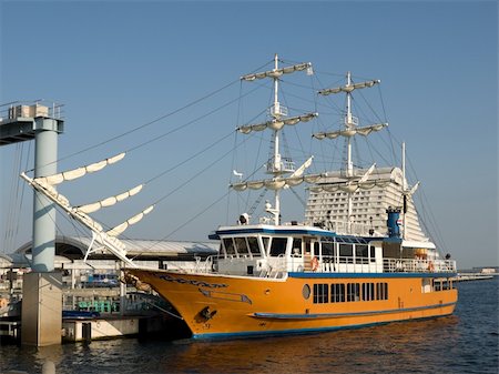 Large yellow sailing boat with white sails docked at Kobe Harborland port area near Kobe Port Tower during the day time Stock Photo - Budget Royalty-Free & Subscription, Code: 400-04482975