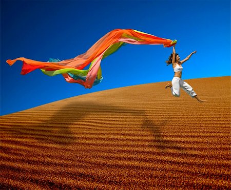 simsearch:400-06077546,k - Beautiful woman jumoping over the sand dunes with a colored scarf Stockbilder - Microstock & Abonnement, Bildnummer: 400-04483431