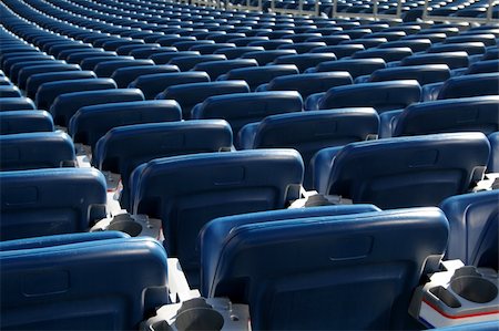 Red staduim seats cast in bright sunshine and shot from behind. Photographie de stock - Aubaine LD & Abonnement, Code: 400-04483620