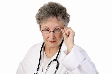 simsearch:400-04117274,k - A mature female doctor staring seriously over her glasses.  White background. Photographie de stock - Aubaine LD & Abonnement, Code: 400-04483960
