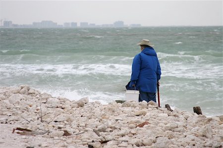 A senior woman, scavenging the beach for treasure as a storm rolls in across the water. Stock Photo - Budget Royalty-Free & Subscription, Code: 400-04483996