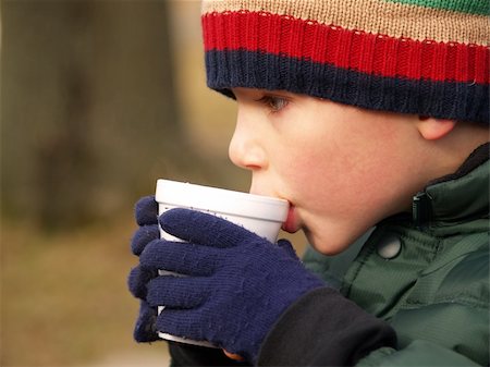 sparkia (artist) - young boy with hat and gloves drinking hot chocolate outdoors Stockbilder - Microstock & Abonnement, Bildnummer: 400-04494048