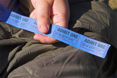 A person holding a string of admission tickets. Fotografie stock - Microstock e Abbonamento, Codice: 400-04496110