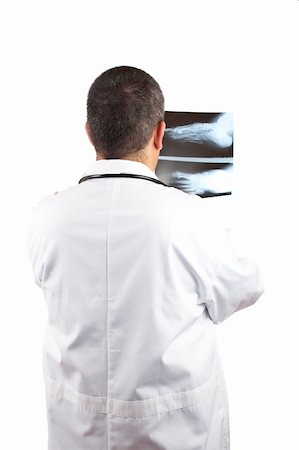 simsearch:400-06634198,k - Friendly male doctor in lab coat, examining x-ray against white background Stock Photo - Budget Royalty-Free & Subscription, Code: 400-04497309