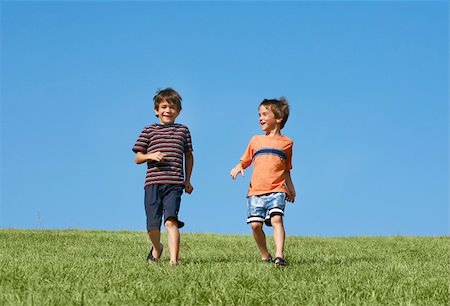 simsearch:400-05166871,k - Two Boys Running Down A Hill on a Beautiful Day Foto de stock - Royalty-Free Super Valor e Assinatura, Número: 400-04498279