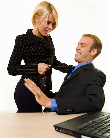 secretary flirting with boss - Business man sitting down with a business woman standing with a knee on his chair pulling on his tie Stock Photo - Budget Royalty-Free & Subscription, Code: 400-04499001