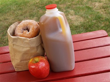 simsearch:400-05033339,k - apple cider, an apple and a bag of cinnamon-sugared donuts on a red picnic table Stock Photo - Budget Royalty-Free & Subscription, Code: 400-04499059
