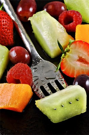 Variety of fresh fruit prepared for a salad on a watery black plate Stock Photo - Budget Royalty-Free & Subscription, Code: 400-04499253