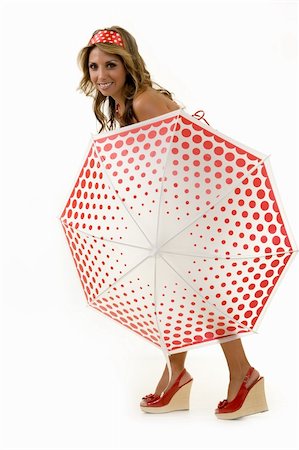 simsearch:400-04741877,k - Full body of a beautiful blond hair woman standing behind a red and white polka dot umbrella with matching headband on white Photographie de stock - Aubaine LD & Abonnement, Code: 400-04499397