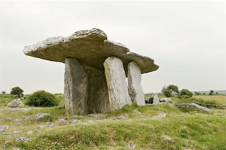 dolmen - The stone table at Poulnabroun is an ancient Celtic relic that was actually built as a tomb. Also known as a dolmen, the enormous slabs of rock were built to protect the dead from the elements. On this overcast and gloomy day, the stone table dominated the landscape. Fotografie stock - Microstock e Abbonamento, Codice: 400-04490131