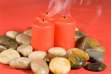 Three red candles smoking in a pile of river rocks isolated against a red background Stock Photo - Budget Royalty-Free & Subscription, Code: 400-04490406