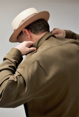 Back view of a man in a pork pie hat adjusting his shirt Foto de stock - Royalty-Free Super Valor e Assinatura, Número: 400-04490474