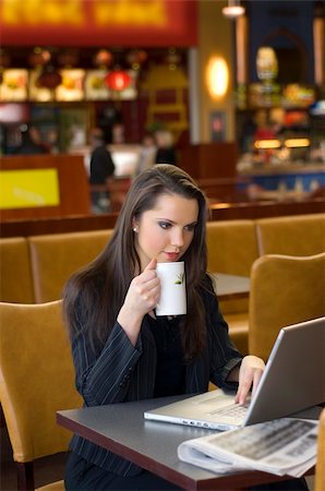 simsearch:400-04504422,k - young woman sitting in a cafe drinking a cup of tea working on laptop Photographie de stock - Aubaine LD & Abonnement, Code: 400-04504421