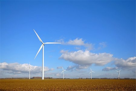 simsearch:400-03912255,k - Wind Turbines in the field with blue cloudy sky Stock Photo - Budget Royalty-Free & Subscription, Code: 400-04505528