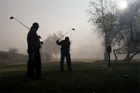 simsearch:400-05038623,k - Early morning golfers silhouetted in a dense fog with a rising sun Stock Photo - Budget Royalty-Free & Subscription, Code: 400-04505627