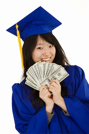 An Asian teenage in blue graduation gown and smiling while hold US money to illustrate to high cost of education.  She is on a white background. Stockbilder - Microstock & Abonnement, Bildnummer: 400-04505658