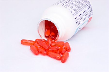 simsearch:400-05074416,k - Red pills being poured from the bottle. The pills are docusate sodium, a laxative. Chosen for their beautiful color. Photographie de stock - Aubaine LD & Abonnement, Code: 400-04505925
