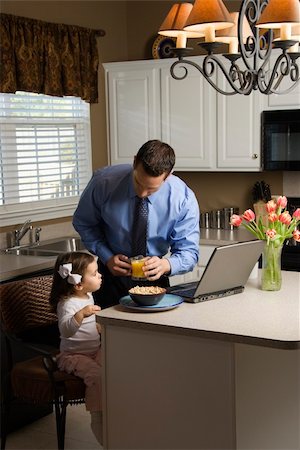 Caucasian father in suit using laptop computer with daughter eating breakfast in kitchen. Stock Photo - Budget Royalty-Free & Subscription, Code: 400-04506010