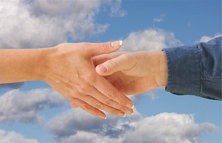 simsearch:400-04000174,k - Man and woman shaking hands on cloud filled blue sky background. Clipping path is included. Stockbilder - Microstock & Abonnement, Bildnummer: 400-04506365