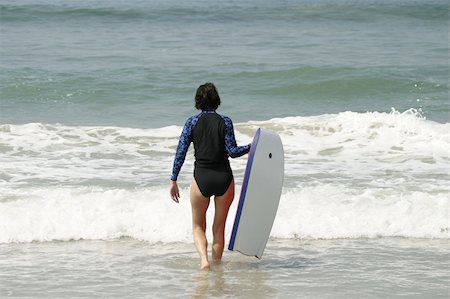 A woman in a swimsuit walking into the surf with a boogie board. This was taken from a beach near Puerto Vallarta in Mexico. Foto de stock - Super Valor sin royalties y Suscripción, Código: 400-04506374