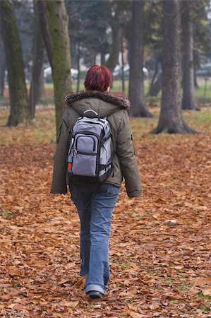 simsearch:400-04110220,k - Redheaded backpacker girl walking in an autumn park.Shot with Canon 70-200mm f/2.8L IS USM Stock Photo - Budget Royalty-Free & Subscription, Code: 400-04506958