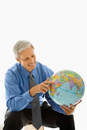 Middle aged Caucasian man holding globe and pointing. Stock Photo - Budget Royalty-Free & Subscription, Code: 400-04507132