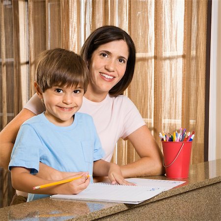 Hispanic mother and son with homework smiling at viewer. Foto de stock - Royalty-Free Super Valor e Assinatura, Número: 400-04507156
