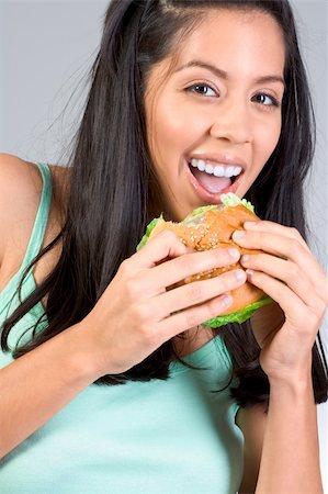 simsearch:400-04028019,k - Cheerful Latina girl eating burger during lunch break Foto de stock - Super Valor sin royalties y Suscripción, Código: 400-04507890