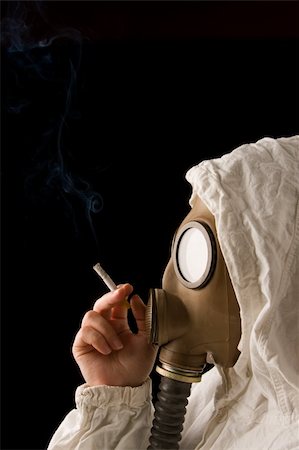 Person in gas mask smoking cigarette on dark background Stock Photo - Budget Royalty-Free & Subscription, Code: 400-04509399
