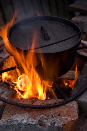 Cooking in a Dutch Oven over a fire Photographie de stock - Aubaine LD & Abonnement, Code: 400-04509583