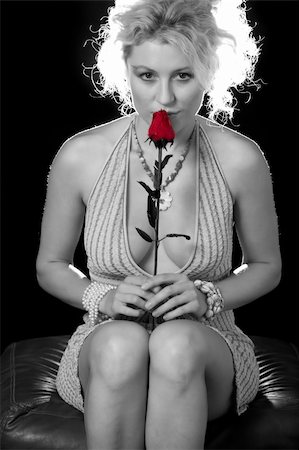 simsearch:400-04502103,k - Full body of an attractive woman with curly blond hair in a sexy low cut dress sitting over black holding a red rose Stock Photo - Budget Royalty-Free & Subscription, Code: 400-04500247