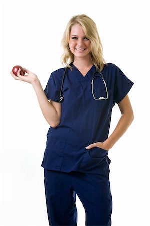 simsearch:400-03995908,k - Young pretty woman healthcare worker wearing blue scrubs and a stethoscope holding a red apple in her hand standing on white Stock Photo - Budget Royalty-Free & Subscription, Code: 400-04500279