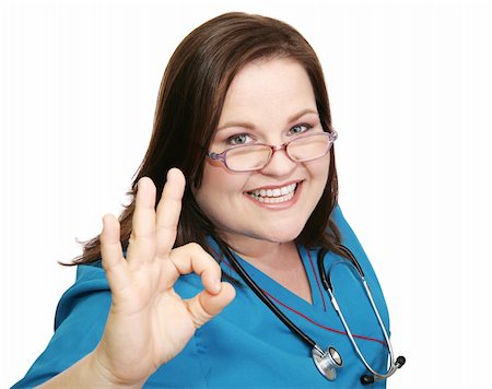 Pretty, enthusiastic nurse in scrubs giving the okay sign.  Isolated on white. Foto de stock - Super Valor sin royalties y Suscripción, Código: 400-04501024