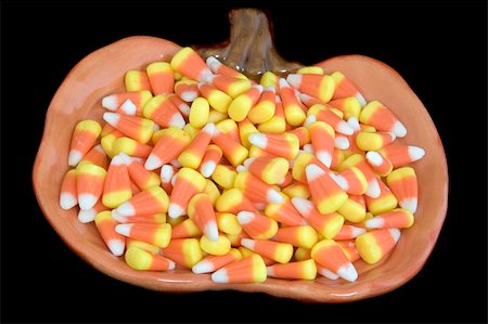 A halloween plate filled with candy corns, on a black background. Stockbilder - Microstock & Abonnement, Bildnummer: 400-04501753