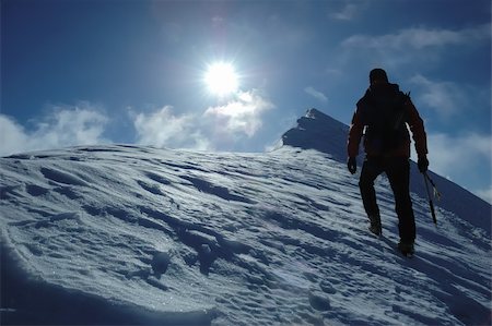 simsearch:400-04126574,k - A lone climber reaching the summit of the mountain; back lite. West Alps, Swiss. Fotografie stock - Microstock e Abbonamento, Codice: 400-04501819