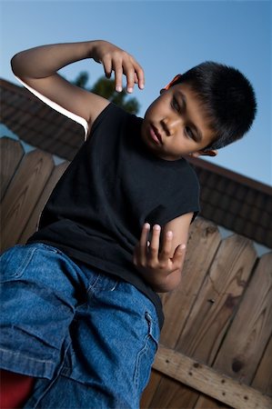 simsearch:400-03994929,k - Young asian boy outside beside a tall wooden fence wearing jeans and black tshirt Stockbilder - Microstock & Abonnement, Bildnummer: 400-04502118