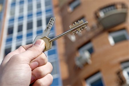 On a background of a modern brick house, hand with keys from an apartment. Stockbilder - Microstock & Abonnement, Bildnummer: 400-04503428