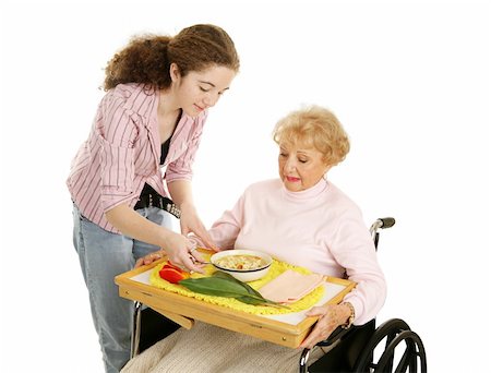 Teen volunteer brings lunch to a disabled senior woman.  Isolated on white. Stock Photo - Budget Royalty-Free & Subscription, Code: 400-04515369